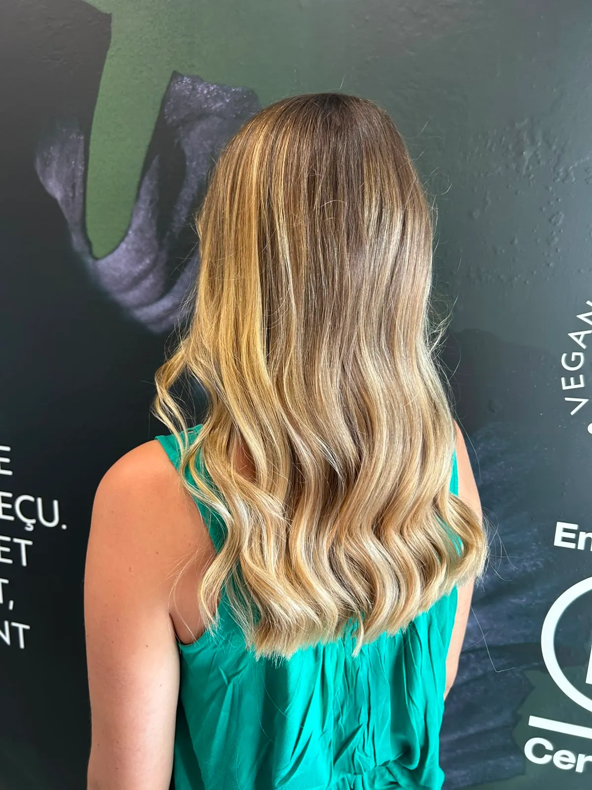 Mèches blondes lumineuses sur cheveux longs ondulés