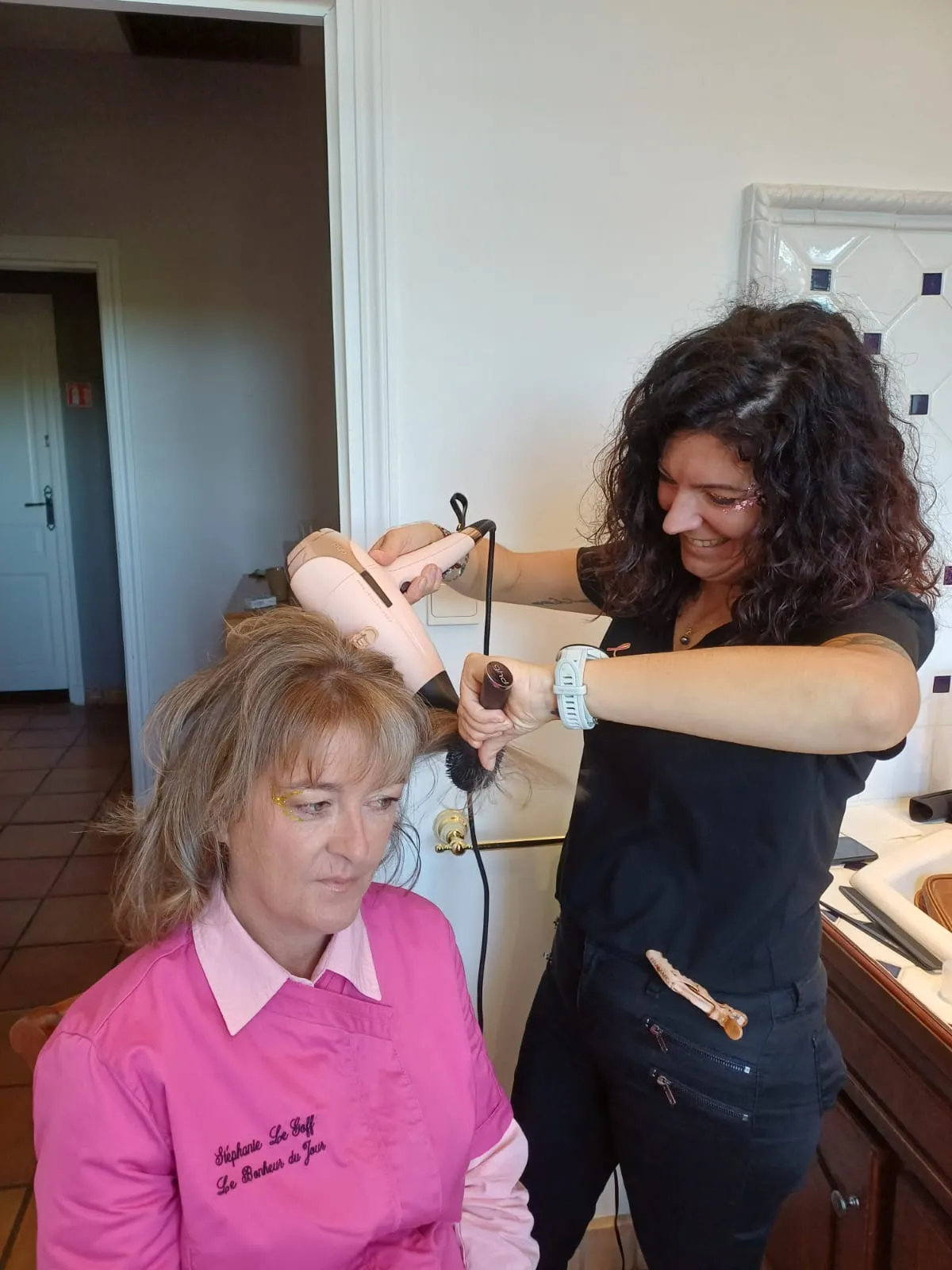 Coiffeuse réalisant un brushing sur les cheveux d’une cliente