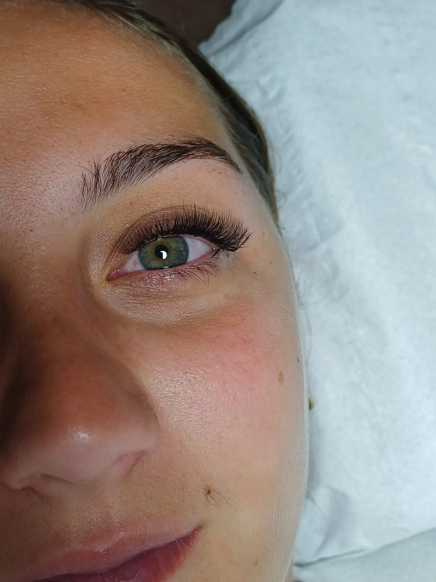 Gros plan sur un œil vert aux cils longs et fournis