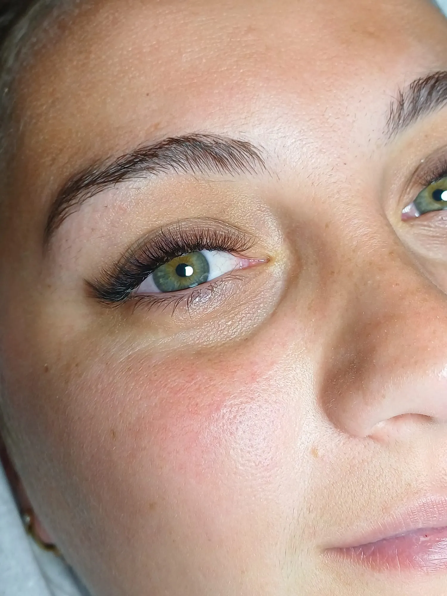 Gros plan sur un regard aux longs cils recourbés et aux iris vert noisette