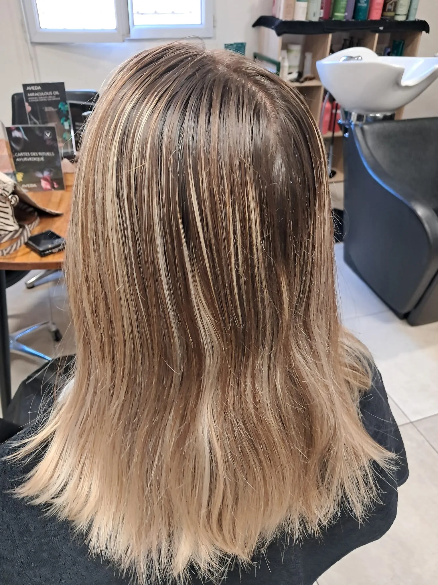 Mèches blond beige sur cheveux mi-longs châtains
