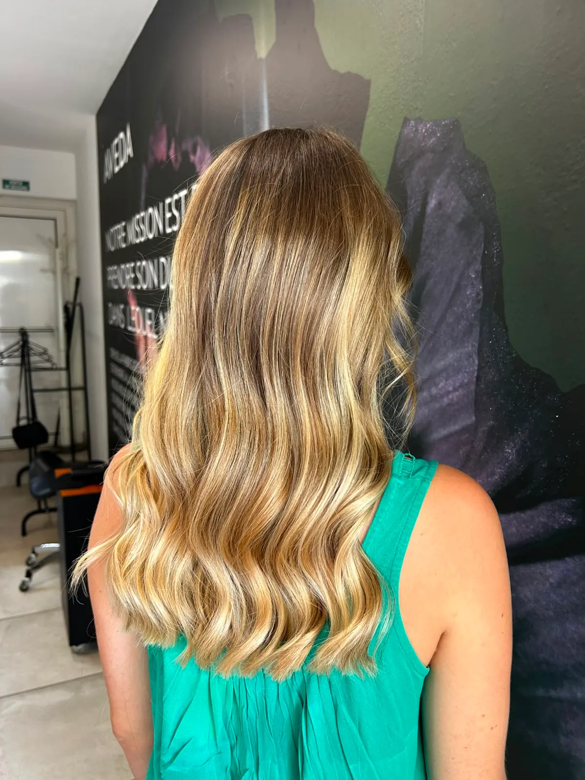 Mèches blondes dorées et ondulations souples sur cheveux mi-longs